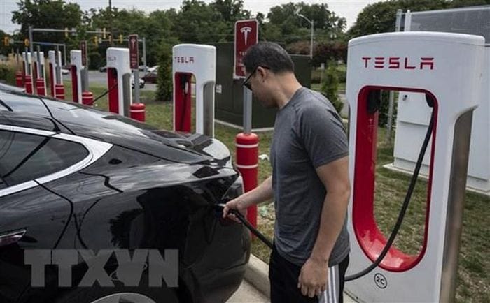 Người dân sạc điện cho ôtô tại một trạm sạc của Tesla ở Arlington, Virginia, Mỹ. (Ảnh: AFP/TTXVN)