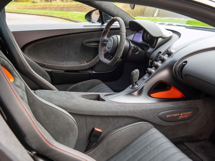 Nội thất của Chiron Super Sport 300+ mang đậm chất thể thao với 2 tông màu đen Beluga Black và cam Jet Orange, với bề mặt ốp sợi carbon, hợp kim anode, Alcantara...