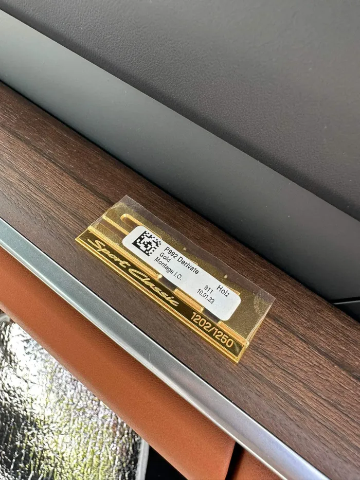  Chủ nhân của chiếc xe đã lựa chọn chất liệu da cao cấp Semi-Aniline màu nâu Classic Cognac và vải Pepita. Logo mang số thứ tự 1202/1250 được đặt tại bảng taplo ghế phụ. 